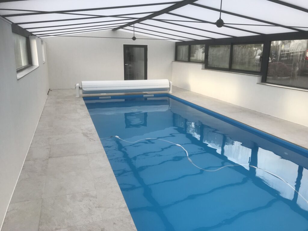 Cette piscine est un couloir de nage installé sous un abri haut pour une utilisation toute l'année en Bretagne.